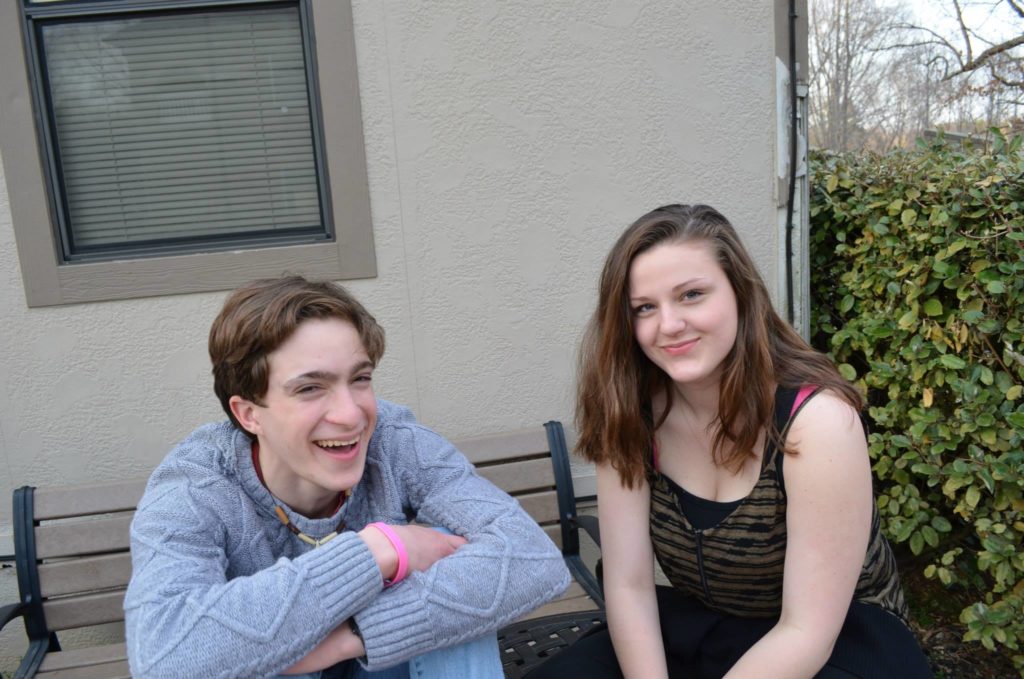 Two students sitting in front of Carlbrook School's student center.