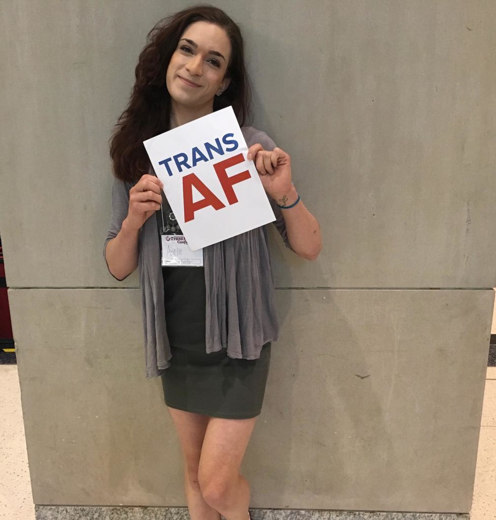 Arielle holding a sign that says, "Trans AF"